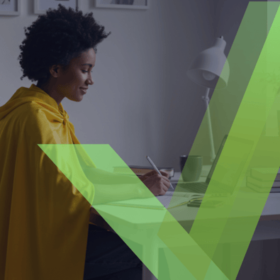 Person writing at desk with laptop and books, green checkmark overlay.